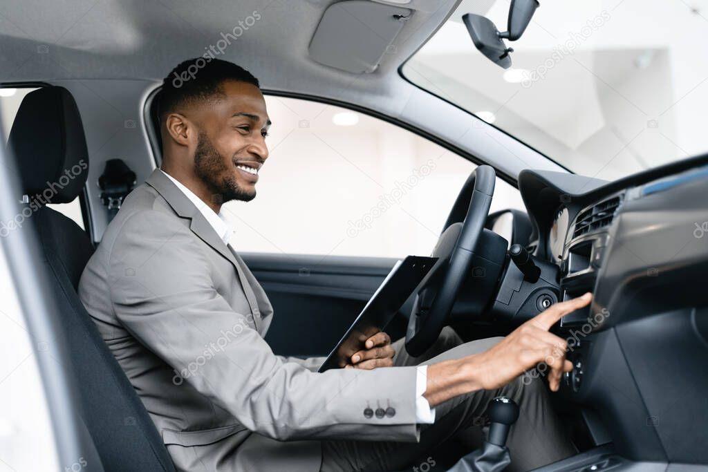 Car Dealer Sitting In Drivers Seat Checking Auto In Showroom