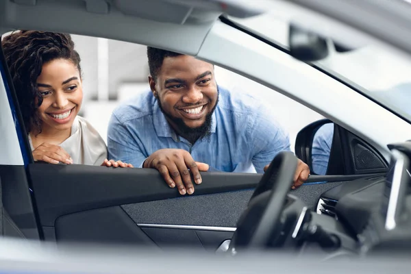 Paar schaut sich Auto-Innenraum an und kauft Familienauto im Autohaus — Stockfoto