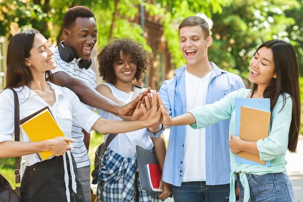 Amitié universitaire. Portrait d'étudiants internationaux joyeux se joignant les mains à l'extérieur — Photo