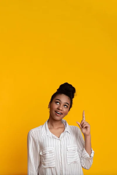 Pensive Afro vrouw wijzend vinger omhoog, hebben idee of inspiratie — Stockfoto