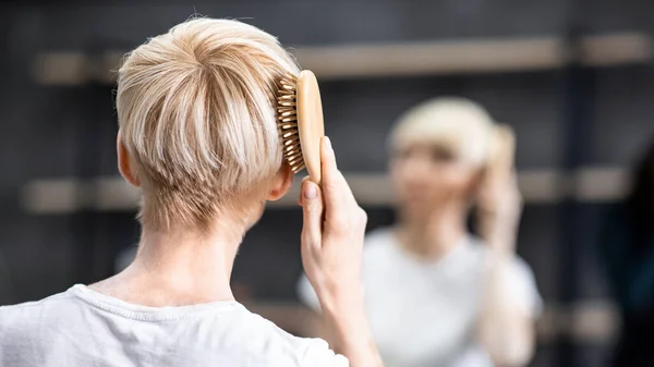 Mujer irreconocible cepillándose el pelo de pie en el baño, Panorama, Vista trasera —  Fotos de Stock