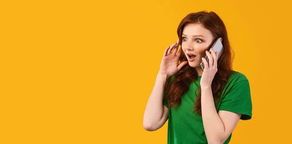 Shocked adolescente chica hablando en el teléfono de pie sobre amarillo fondo — Foto de Stock