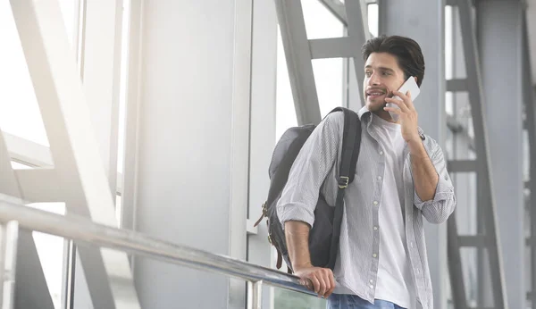 Hombre viajero hablando por celular en el aeropuerto, esperando el embarque para el vuelo — Foto de Stock