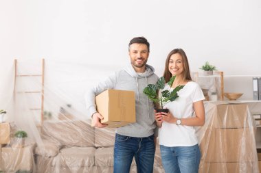 Birbirine aşık genç bir çift kutuları tutuyor ve mutlu bir şekilde taşınıyor.