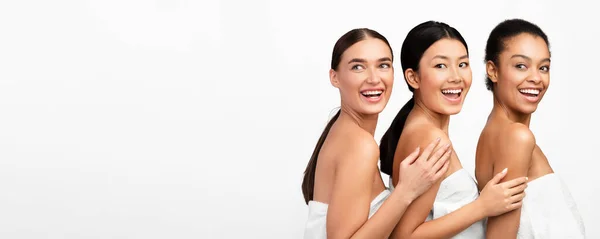Drie multiraciale vrouwen poseren in bad handdoeken, witte achtergrond, Panorama — Stockfoto