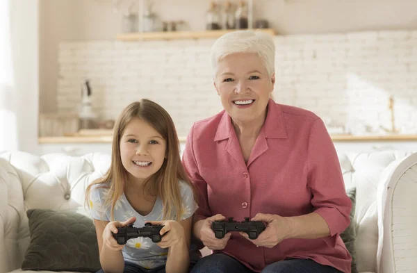 Feliz niño y su abuela jugando videojuegos juntos en casa — Foto de Stock