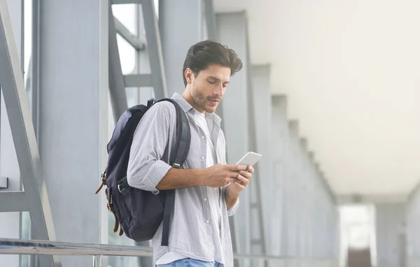Registro en línea. Hombre con mochila usando Smartphone en la terminal del aeropuerto — Foto de Stock