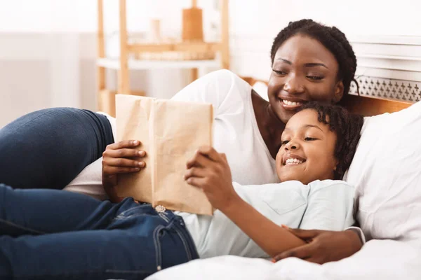 Feliz afro família leitura livro no quarto — Fotografia de Stock