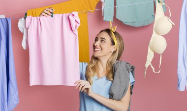 Washing day concept. Happy housewife hangs clean clothes