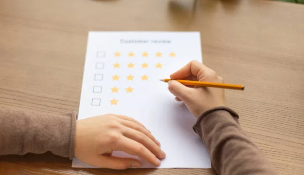 Woman thinking about customer review sheet, wooden background — Stok fotoğraf