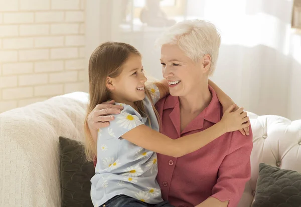 Older woman with her grandchild hugging at home — Stock Photo, Image