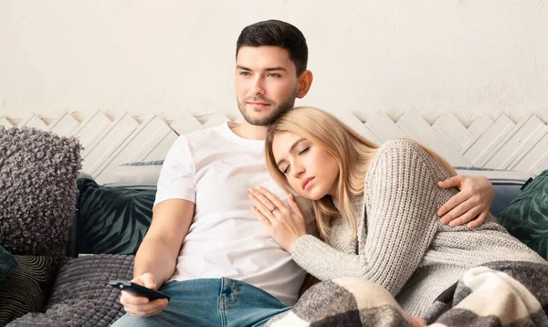 Jovem assistindo TV enquanto sua namorada dorme em casa, panorama — Fotografia de Stock