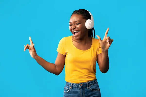 Cheerful African Girl In Earphones Singing Posing Over Blue Background — Φωτογραφία Αρχείου