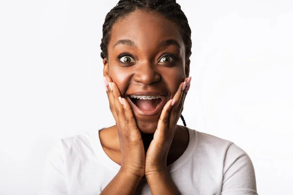 Garota excitada com aparelhos gritando em emoção no fundo branco — Fotografia de Stock