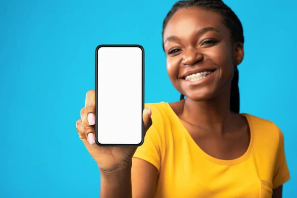 Girl Showing Smartphone Blank Screen Over Blue Studio Background, Mockup — Stock Photo, Image