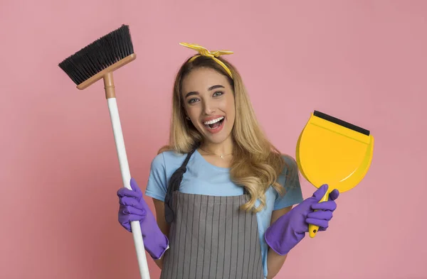 Concetto di pulizia casa. Casalinga sorridente con scopa e pala in mano — Foto Stock