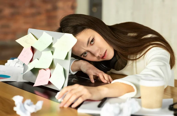 Concetto di lavoro eccessivo. Ragazza triste sdraiato sul computer portatile — Foto Stock