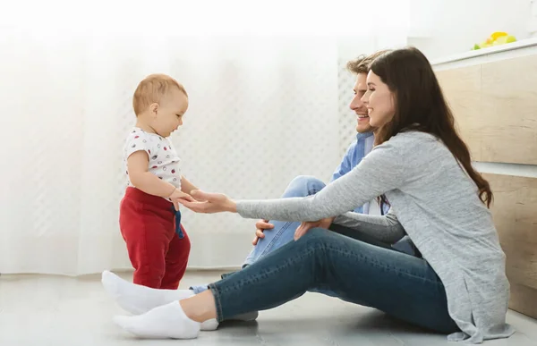 Family of three enjoying time together at kitchen floor at home — Stockfoto