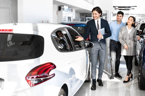 Dealer Showing Young Family New Auto In Dealership Store — Stock Photo, Image