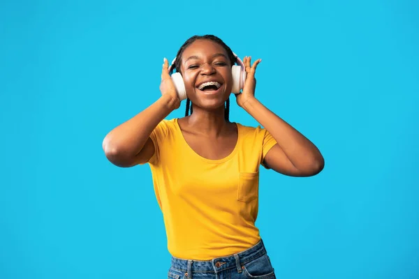 African American Girl In Earphones Enjoying Music Over Blue Background — Stock Fotó