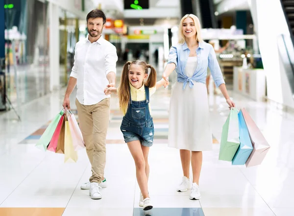 Alışveriş merkezinden alışveriş yaptıktan sonra alışveriş yapan üç kişilik bir aile. — Stok fotoğraf