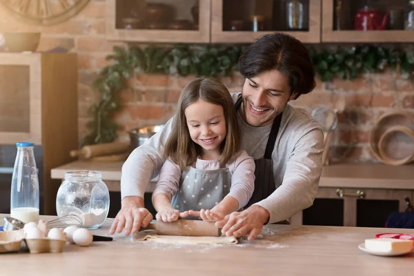 Boldog apa és a lánya együtt gyűjtik össze a tésztát a konyhában. — Stock Fotó