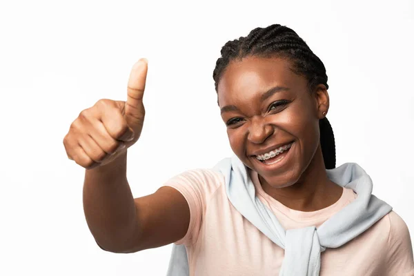 Улыбающаяся афроамериканская девочка, поднимающая вверх пальцы над белым фоном — стоковое фото