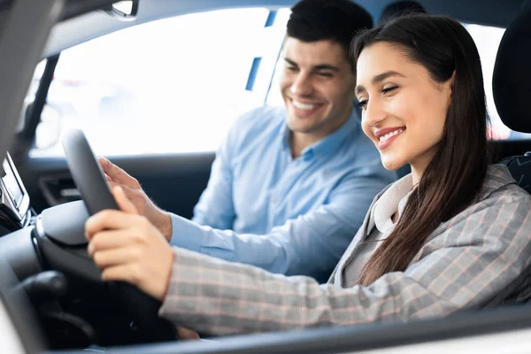 Los cónyuges jóvenes eligen el coche en la tienda de concesionarios — Foto de Stock