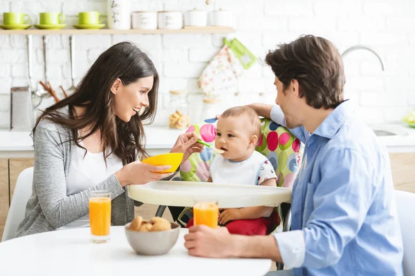 Genç bir aile, küçük oğluyla kahvaltı yapıyor. — Stok fotoğraf