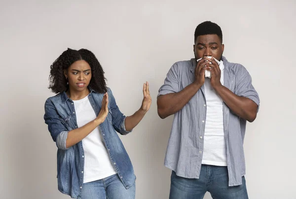 Infection Awareness. Disgusted black woman keeping distance with her sick boyfriend — Stock Photo, Image