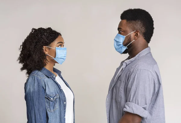 Virus Alert. Profile Portrait Of Frightened Black Couple In Protective Masks