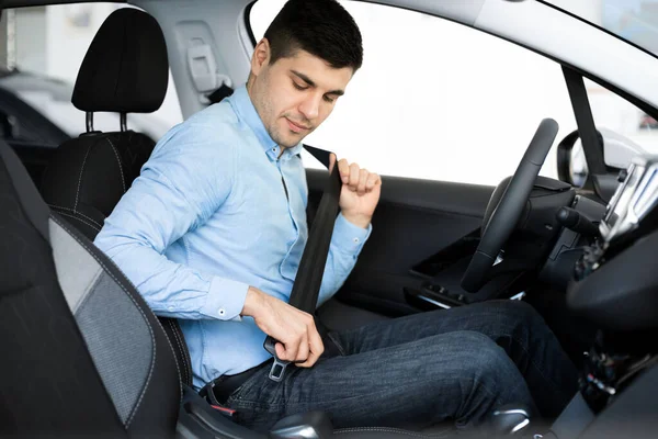 Kerl legt Sicherheitsgurt an und sitzt im Auto — Stockfoto