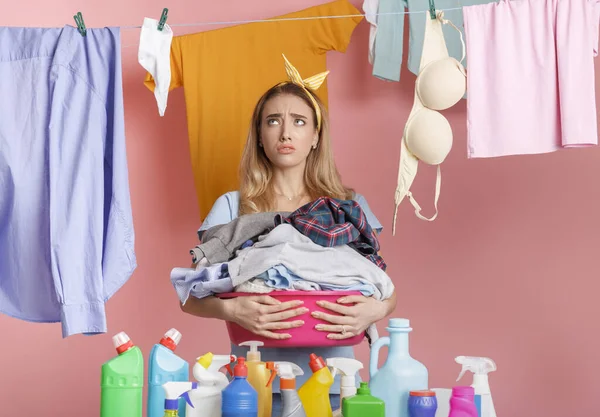 Femme au foyer fatiguée avec lavabo dans les mains regarde des vêtements propres — Photo