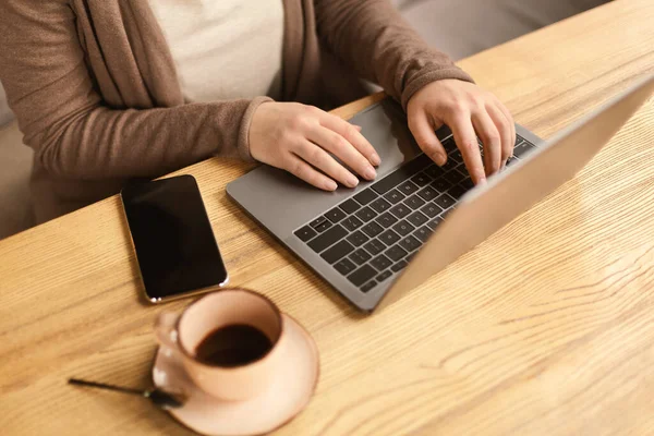 Female working on laptop and drinking coffee — Stok fotoğraf