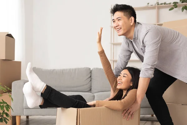 Asiático hombre y mujer tener divertido en su nuevo apartamento —  Fotos de Stock