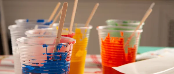 Colores acrílicos del artista en vasos de plástico en el estudio de arte — Foto de Stock