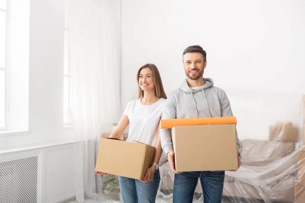 새 아파트로 이사 한 여자와 남자가 상자를 들고 있는 모습 — 스톡 사진