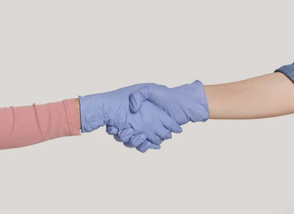 Apretón de manos de dos personas con guantes médicos azules, primer plano — Foto de Stock