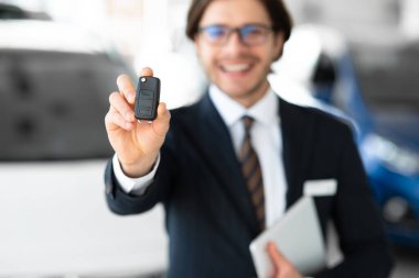 Man Showing Key Standing In Automobile Rental Office