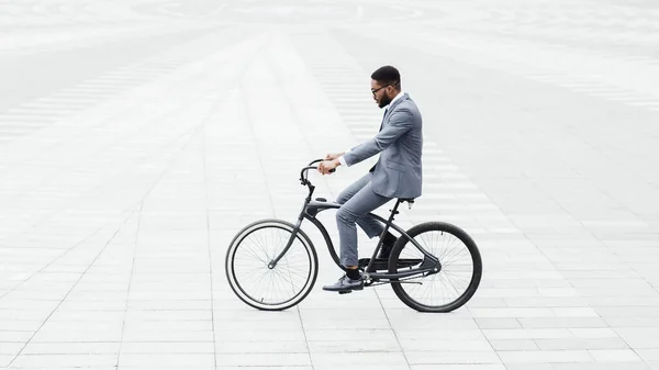 Bonito empresário afro andando de bicicleta para o trabalho, isolado — Fotografia de Stock