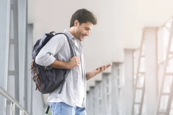 Joven con mochila y smartphone en el aeropuerto esperando la salida — Foto de Stock