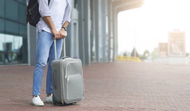 Waiting For Transfer. Unrecognizable Man Standing Near Airport Terminal With Luggage