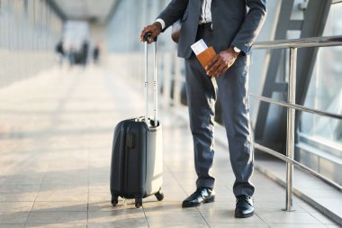 Unrecognizable Entrepreneur Holding Passport And Flight Tickets Standing In Airport