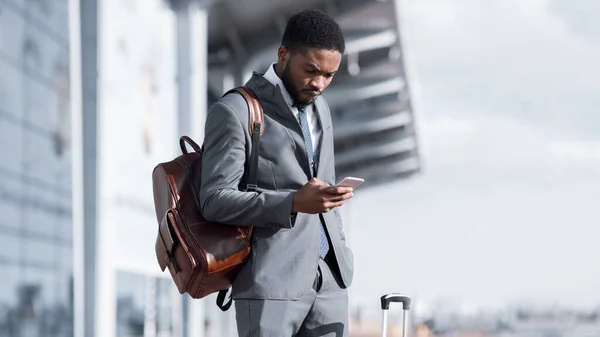 Empresario usando Smartphone Mensaje de lectura sobre la cancelación del viaje en el aeropuerto — Foto de Stock