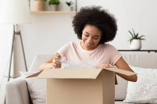 African american girl customer unpacks a box — Φωτογραφία Αρχείου