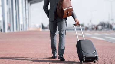 Businessman With Suitcase Walking Back To Camera Near Airport, Cropped
