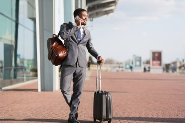 Businessman Talking On Phone Standing With Suitcase At Airport Outdoor