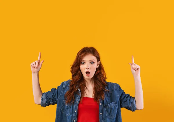 Amazed Teen Girl Pointing Fingers Upward Standing Over Yellow Background — Stock fotografie