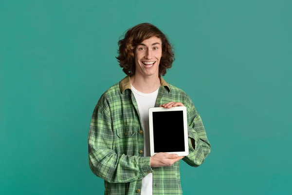 Handsome millennial guy holding tablet computer with blank screen on color background, mockup for your design — 스톡 사진