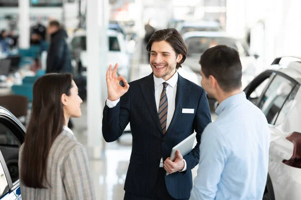 Negociante de carro Gesturing Ok conversando com os clientes — Fotografia de Stock